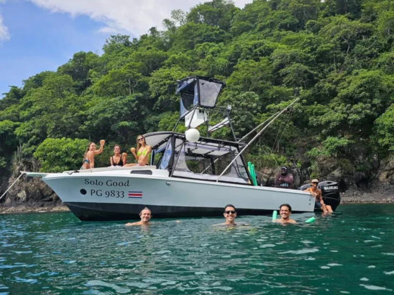 Guests swimming alongside a Solo Good fishing charter boat in Playa Potrero, Costa Rica