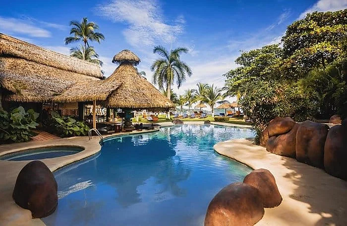 The thatched-roof poolside area at Bahia Del Sol beachfront hotel in Playa Potrero, Costa Rica