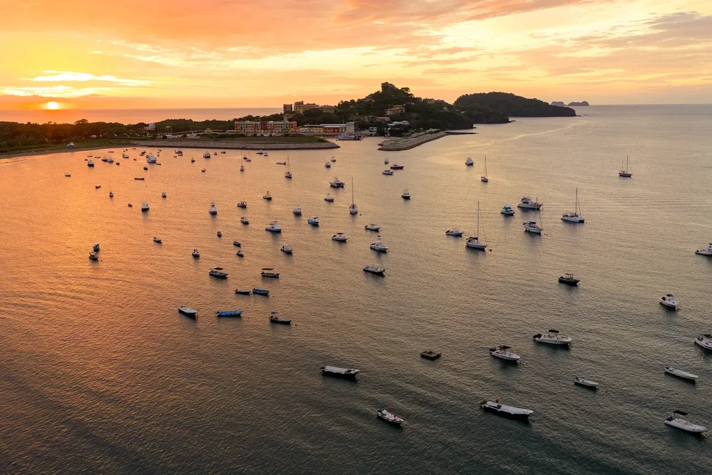 Aerial view of Flamingo Marina at sunset, with fishing boats and sailboats anchored in the bay off Playa Flamingo, Guanacaste, Costa Rica