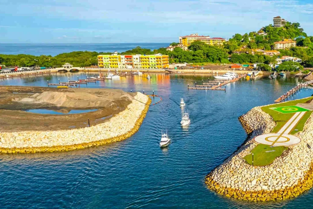 Two fishing charter boats heading out through the Flamingo Marina channel past the breakwater, Guanacaste, Costa Rica