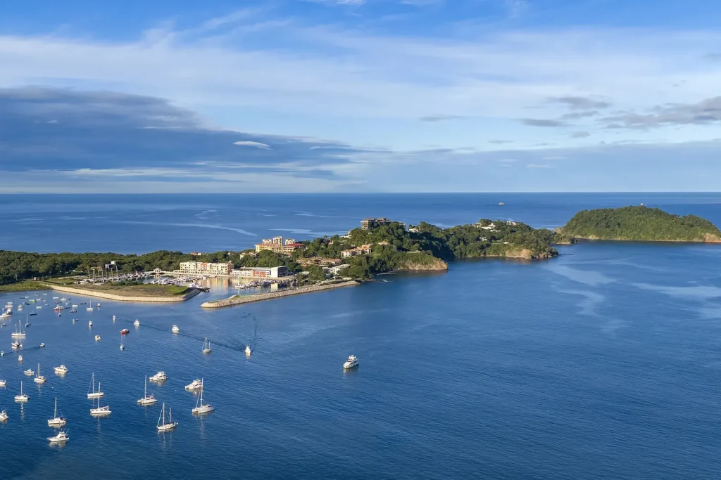 Aerial view of Flamingo Marina behind the headland with the open Pacific and offshore islands beyond, Guanacaste, Costa Rica