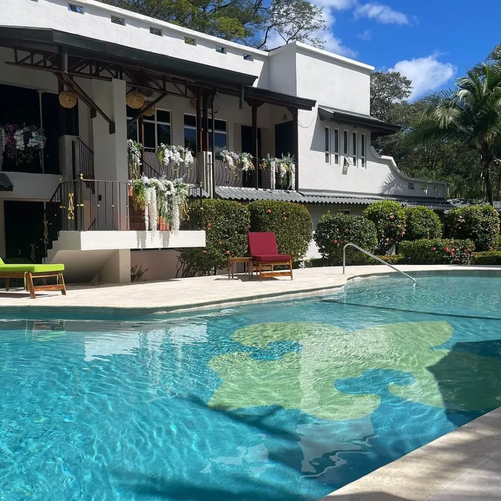The pool and flower-draped balcony at Parti Gras Hotel, a short walk from the beach in Playa Potrero, Costa Rica ← tweaked slightly to mention the distinctive flower balcony that's now visible