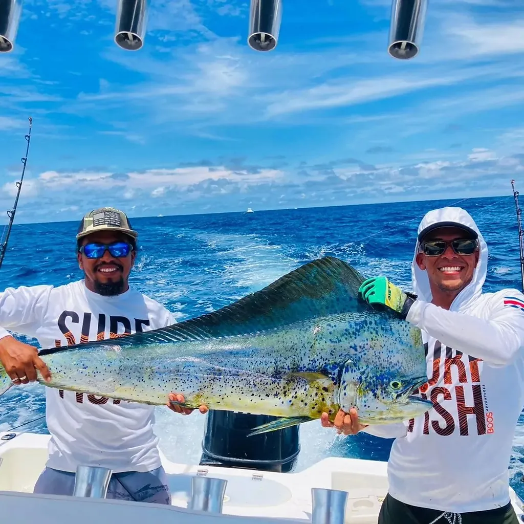 Two crew members holding a large mahi-mahi caught aboard the Sea Hunt fishing charter off Playa Potrero, Costa Rica
