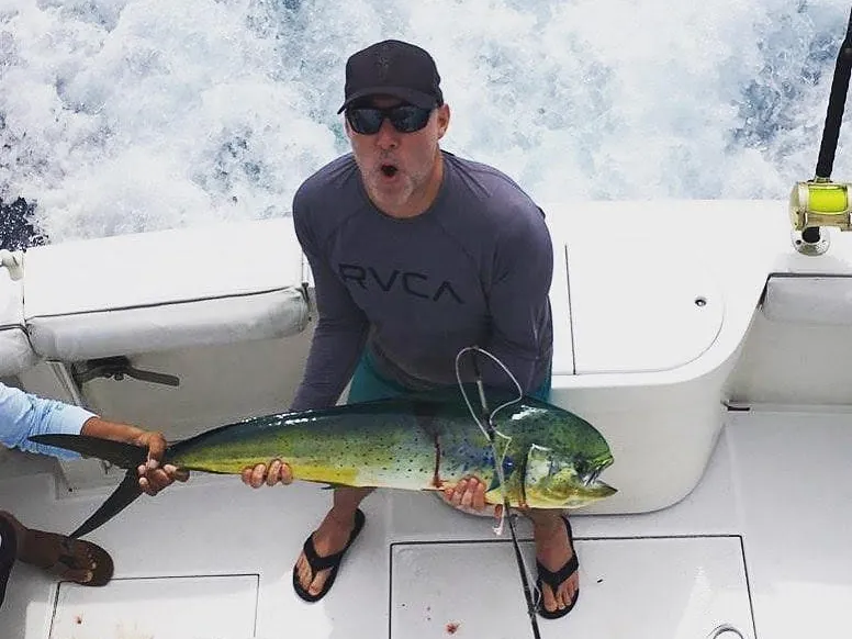 Angler holding a mahi-mahi caught aboard a Victory Sport Fishing charter off Playa Potrero, Costa Rica